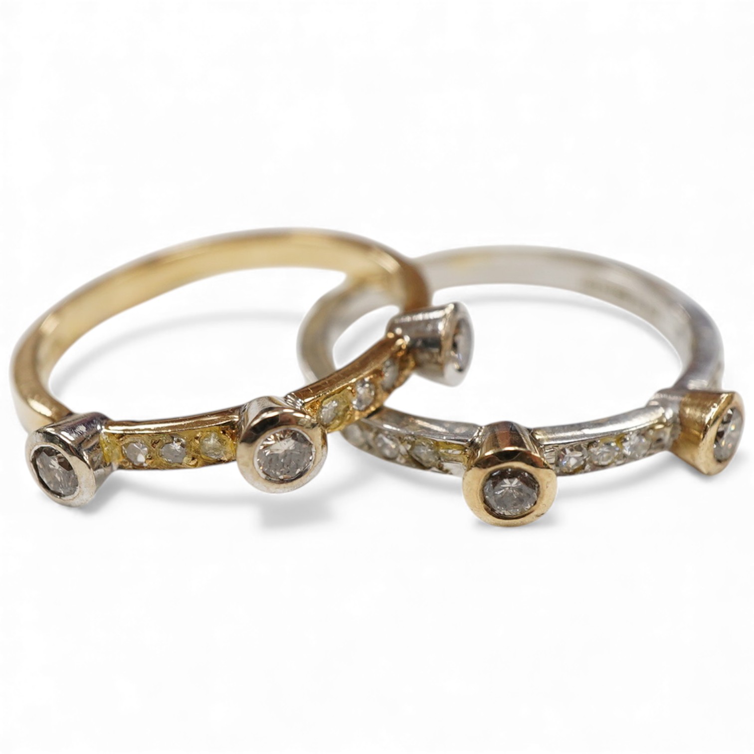 Two modern similar 14ct gold and diamond rings, one in yellow gold, with three collet set stones and six smaller stones, size P/Q, the other set in 9ct white gold, with two collet set stones and eleven smaller stones, si